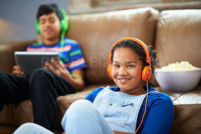 Buy stock photo Tablet, children and portrait of girl with headphones in streaming, music or audio book with her brother at home. Kids, family and siblings in living room with digital, app or radio, relax or bonding