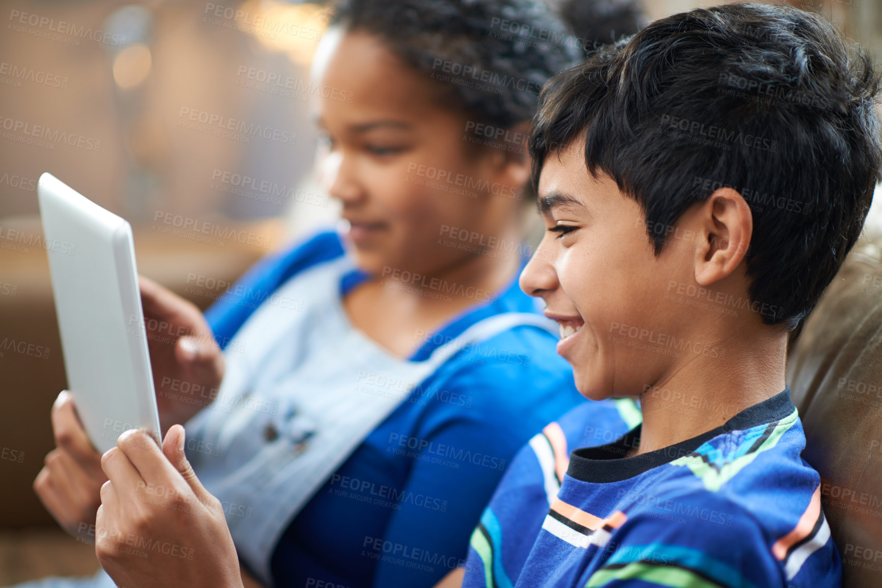 Buy stock photo Cropped shot of a little brother and sister watching something on a tablet