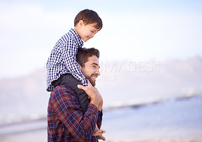 Buy stock photo A father carrying his young son on his shoulders with a smile