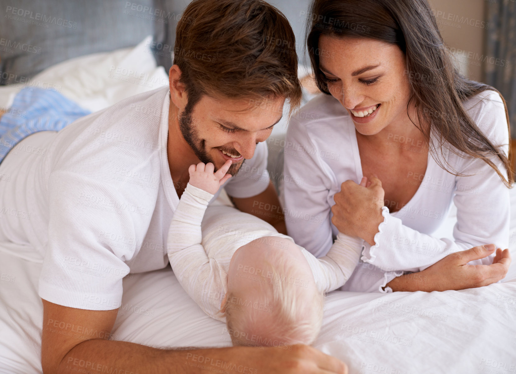 Buy stock photo Mom, dad and baby in bedroom for love, care and quality time together. Happy family, parents and newborn child relaxing on bed with smile, childhood development and support to nurture kids at home 