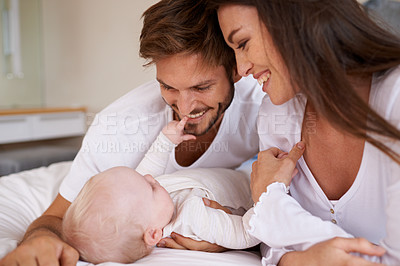Buy stock photo Happy father, mother and baby on bed for love, care and quality time together. Parents, newborn kid and relax in bedroom of family home with smile, childhood development and caring support of bonding