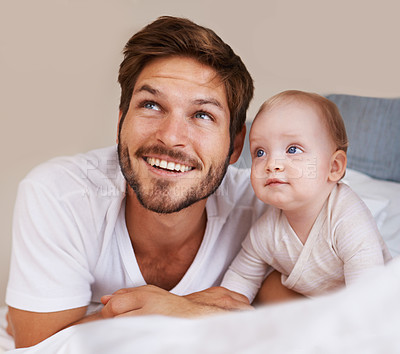 Buy stock photo Happy, cute and baby with father on bed relaxing, playing and bonding together at home. Smile, love and young dad laying with girl child, infant or kid in bedroom or nursery at family house.