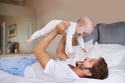 Buy stock photo Father, on bed and holding his baby girl up in the air or playful daughter and having fun in the bedroom feeling happy. Parent, kid and dad bonding or carefree and excited together in the house