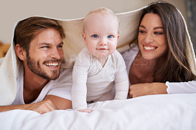 Buy stock photo Portrait of baby, happy mother and father with blanket in bedroom for love, care and quality time together. Fun parents, playful newborn child and family relaxing with bedding fort, smile and at home