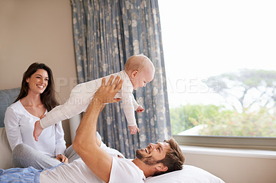 Buy stock photo Happy family playing with baby in air, bedroom and fun of love, care and quality time to relax together at home. Mom, dad and holding playful infant kid for happiness, support and newborn development