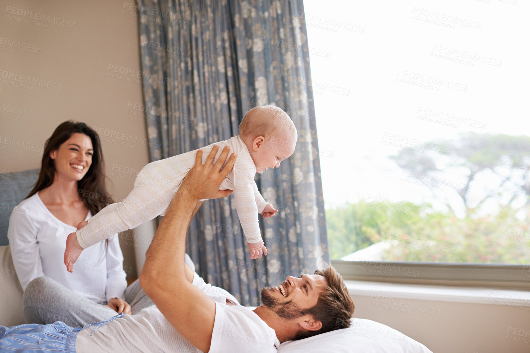 Buy stock photo Happy family playing with baby in air, bedroom and fun of love, care and quality time to relax together at home. Mom, dad and holding playful infant kid for happiness, support and newborn development