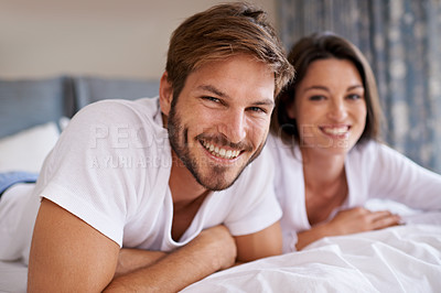 Buy stock photo Happy, love and portrait of couple relaxing, bonding and resting on bed together at home. Smile, romantic and young man and woman laying in bedroom at hotel for weekend trip, vacation or holiday.