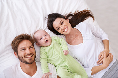 Buy stock photo Top view, portrait and happy parents with baby on bed for love, care and quality time together at home. Smile of mother, father and family with cute newborn kid relaxing in bedroom, fun and happiness