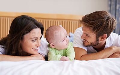 Buy stock photo Happy family, mother and father with baby on bed for love, care and fun quality time together at home. Parents, cute newborn child and bonding to relax in bedroom for support, nurture and happiness