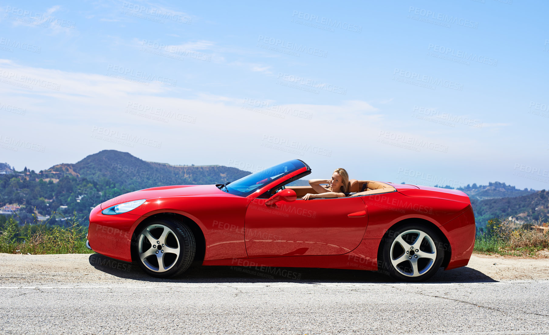 Buy stock photo Woman, red convertible and road trip on mountain, travel and luxury transport on summer drive. Happy female person, holiday and countryside wellness on street, vacation and adventure in vehicle