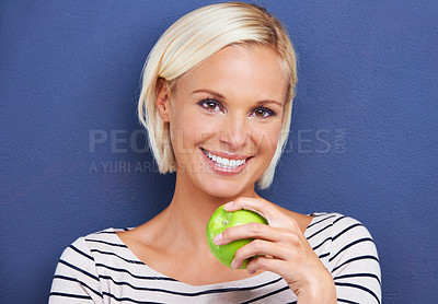 Buy stock photo Woman, portrait and apple in studio or healthy diet on blue background or fruit nutrition, snack or fibre. Female person, relax and wellness eating or mockup space as vegan detox, food or lose weight