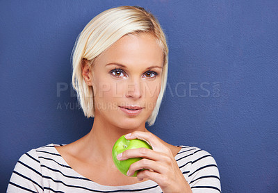 Buy stock photo Woman, portrait and apple in studio for nutrition diet on blue background or fruit vitamin, snack or fibre. Female person, relax and wellness eating or mockup space as vegan detox, raw or lose weight