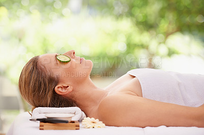Buy stock photo Woman, massage and spa with cucumber treatment for skincare facial or wellness, detox or stress relief. Female person, eyes closed and calm on table at zen resort for luxury, peace or comfortable
