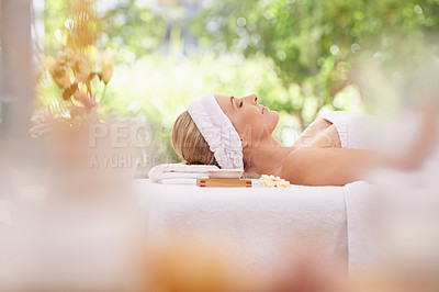 Buy stock photo Lady, spa and rest for zen, peace and wellness with relaxation and calm. Woman, towel and massage table at resort, lounge or luxury parlor with rose for holistic body and skincare for detox and break