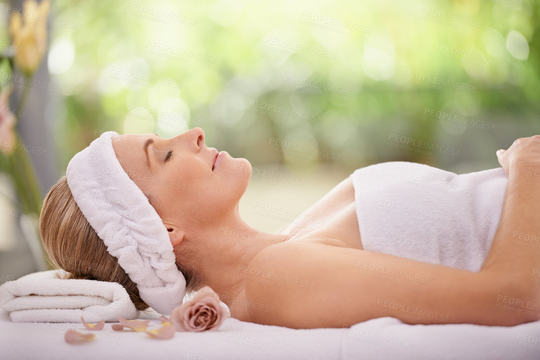 Buy stock photo Cropped shot of a woman in a day spa relaxing on a massage table