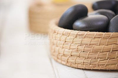 Buy stock photo Stone, massage and closeup on basket in spa for luxury service in hospitality at hotel on holiday or vacation. Rocks, container and object for wellness treatment on table or detail of pebble