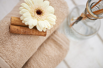 Buy stock photo Flower, cinnamon stick and towels for aromatherapy at spa, incense and spices for holistic healing. Top of tools for treatment, stress relief and self care with natural ingredients and glass bottle 