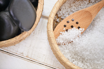 Buy stock photo Basket, stone and salt closeup in spa for luxury service in hospitality at hotel on holiday or vacation. Rocks, container and object for wellness treatment on table with detail of pebble or minerals