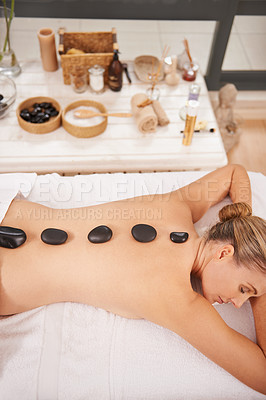 Buy stock photo Woman, top view and hot stone massage at spa with aromatherapy, body for treatment and wellness with zen. Calm, peace and luxury with warm rocks for detox, self care and holistic healing at resort