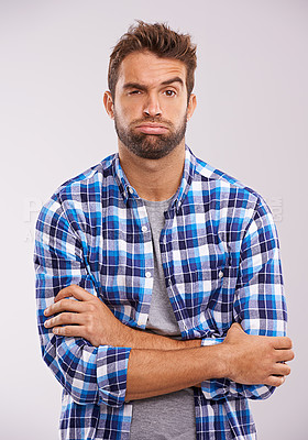 Buy stock photo Frustrated, tired and portrait of a man with arms crossed in a studio feeling annoyed and bored. Isolated, white background and male model with upset face and grumpy with casual fashion and doubt