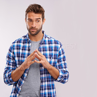 Buy stock photo Shot of a young man considering something against gray background