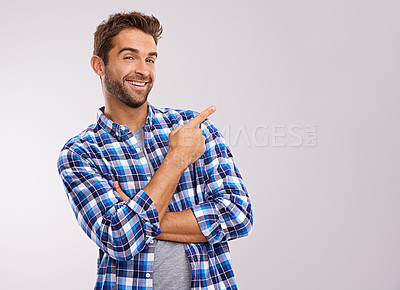 Buy stock photo Portrait, pointing and casual man in studio with smile, deal announcement and happy face. Showing, advice and creative person at presentation at offer, notification and white background mockup