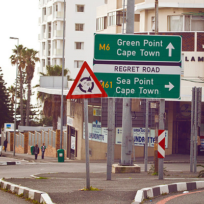 Buy stock photo Road sign, intersection and circle in city with arrow for grammar, mistake or comic text for driving in neighborhood. Buildings, error and funny signage with joke, regret and warning in Cape Town