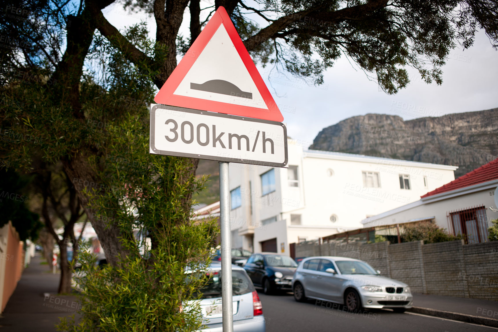 Buy stock photo Road sign, warning and red triangle signage in street for speedbump with caution notification and speed limit. Attention, public notice and signpost for urban town, alert message and symbol by trees