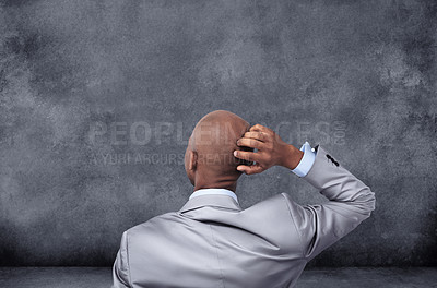 Buy stock photo Rearview shot of a businessman scratching his head while looking at a chalkboard