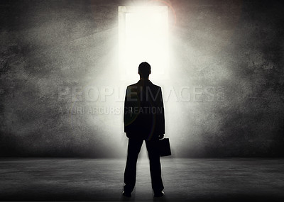 Buy stock photo Conceptual shot of a businessman looking towards a bright doorway