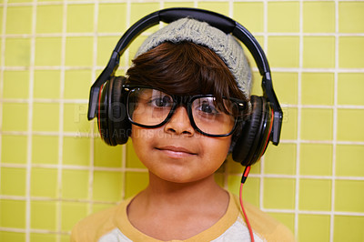 Buy stock photo Child, portrait and glasses with headphones in home with music and streaming. Radio, eyewear and youth fashion with a hipster Indian boy listening to audio with cool style in a house with frames