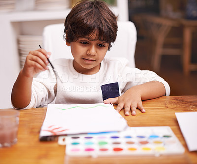 Buy stock photo Little boy, painting and drawing with brush on paper for art, design or creativity with color at home. Young child or kid with smile and paintbrush for colorful palette, artwork or artistic skills