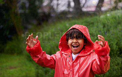 Buy stock photo Shot of a little boy wearing a raincoat playing outside