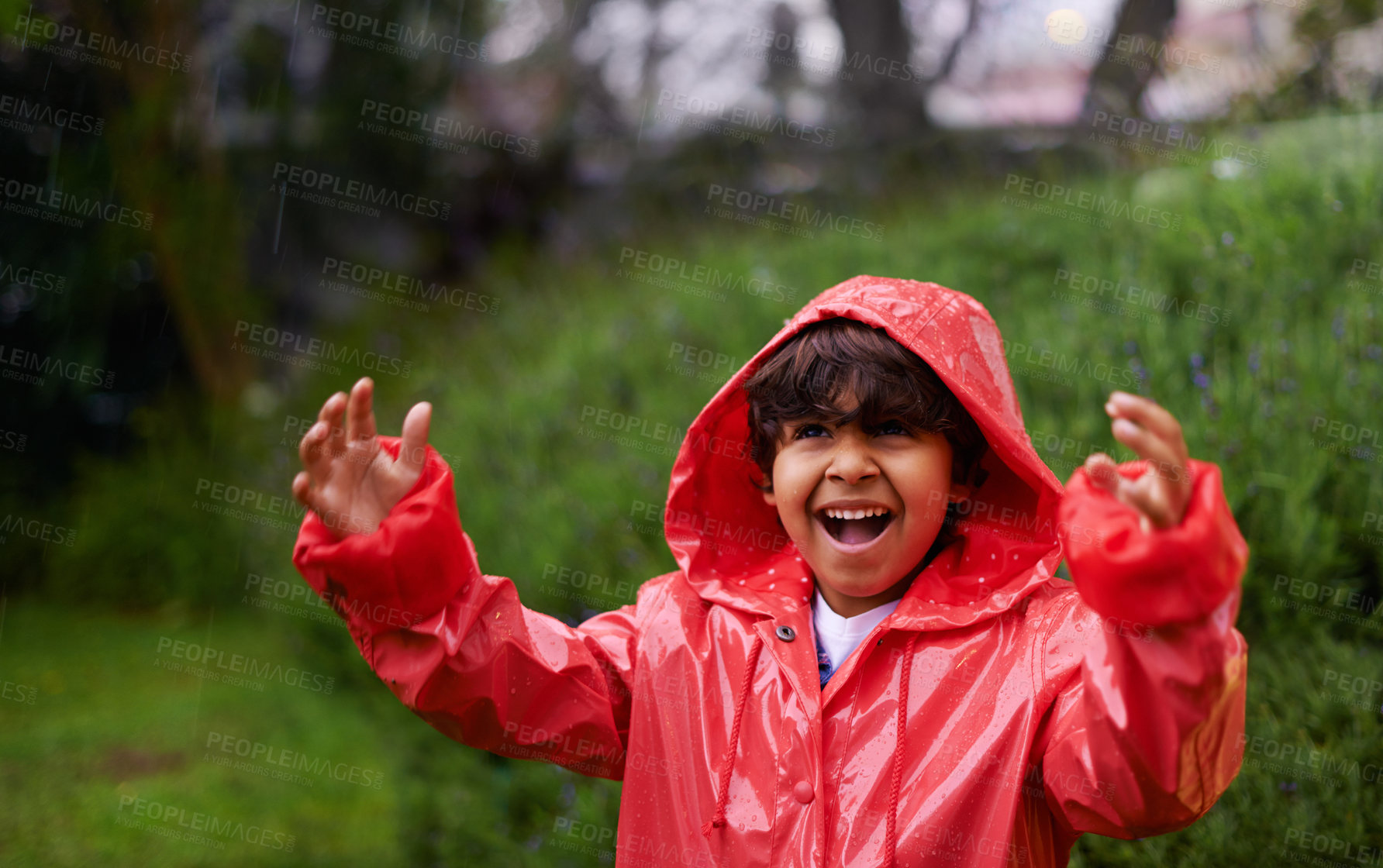 Buy stock photo Shot of a little boy wearing a raincoat playing outside