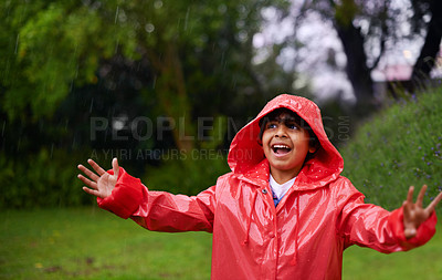 Buy stock photo Rain, celebration and excited boy in a forest for adventure, freedom or exploring games in nature. Winter, travel and happy kid with raincoat in India outdoor for learning, journey or storm surprise