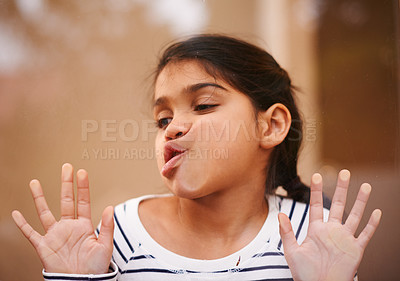 Buy stock photo Window, face and funny girl with cheek press comic in her house with silly, joke or goofy gesture. Glass, mouth or Indian child with humor, games or playing on vacation, holiday or weekend in India