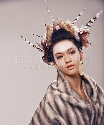 Buy stock photo Woman, portrait and cultural fashion with Native American in tradition or art on a gray studio background. Female person with feather, face paint or stylish tribal clothing of goddess in beauty
