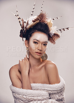 Buy stock photo Woman, portrait and native american headdress in studio with feather, hair and beauty with culture cosmetics. Model, face and indigenous make up or art and elegant fashion or cloth on grey background