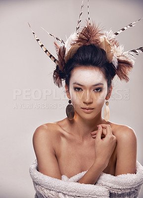 Buy stock photo Model, portrait and native american headdress in studio with feather, hair and beauty with culture cosmetics. Woman, face and indigenous make up or art and elegant fashion or cloth on grey background