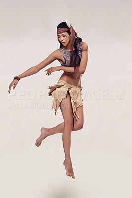 Buy stock photo Dance, woman and Native American fashion in studio with warrior makeup, confidence and tribe style. Indigenous culture, performance or girl in First Nations clothes on white background with jump