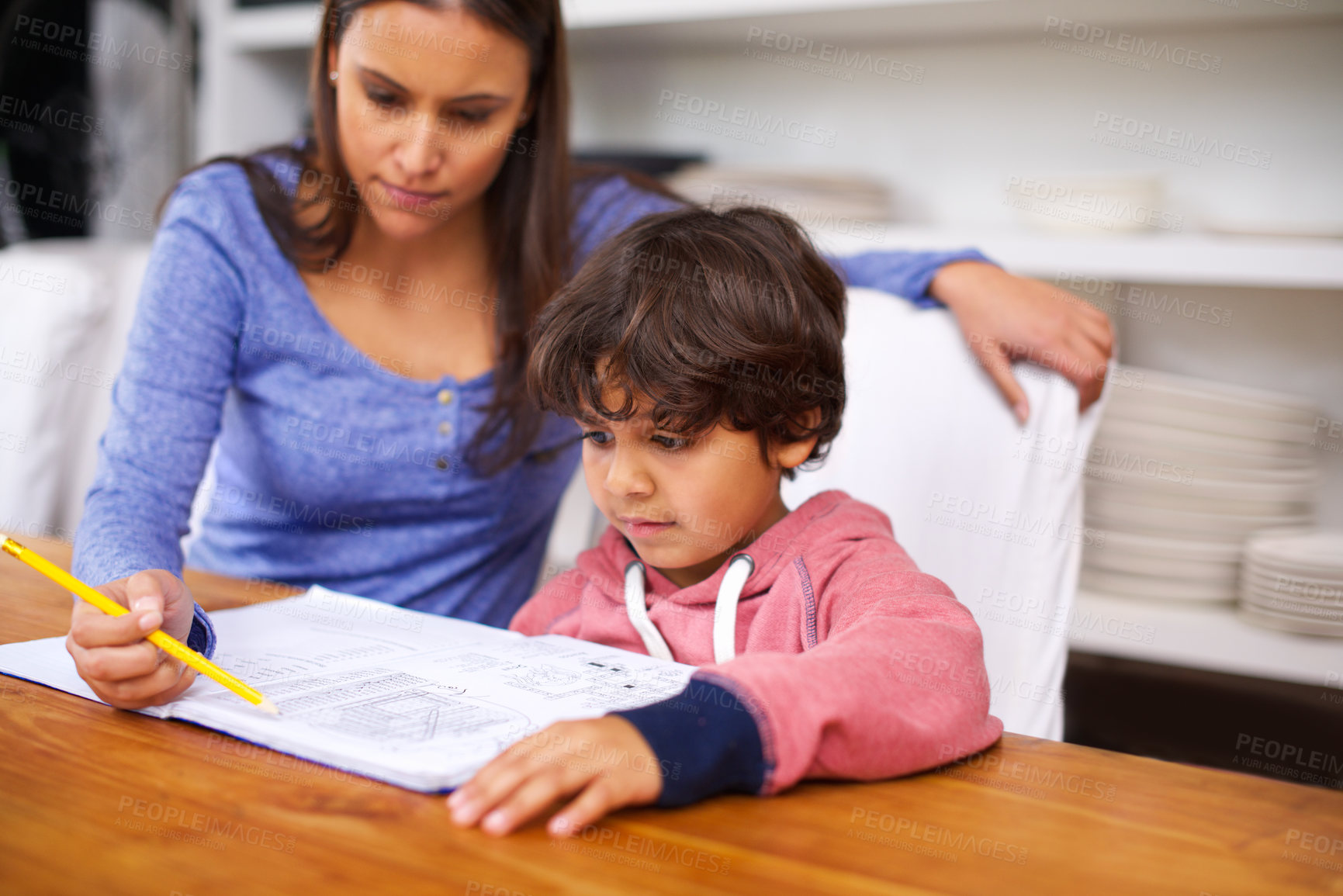 Buy stock photo Woman, help and child in house with book for homework, learning and education for grades, study and development. Diverse people, mother and boy with note and pencil for teach, writing and childhood