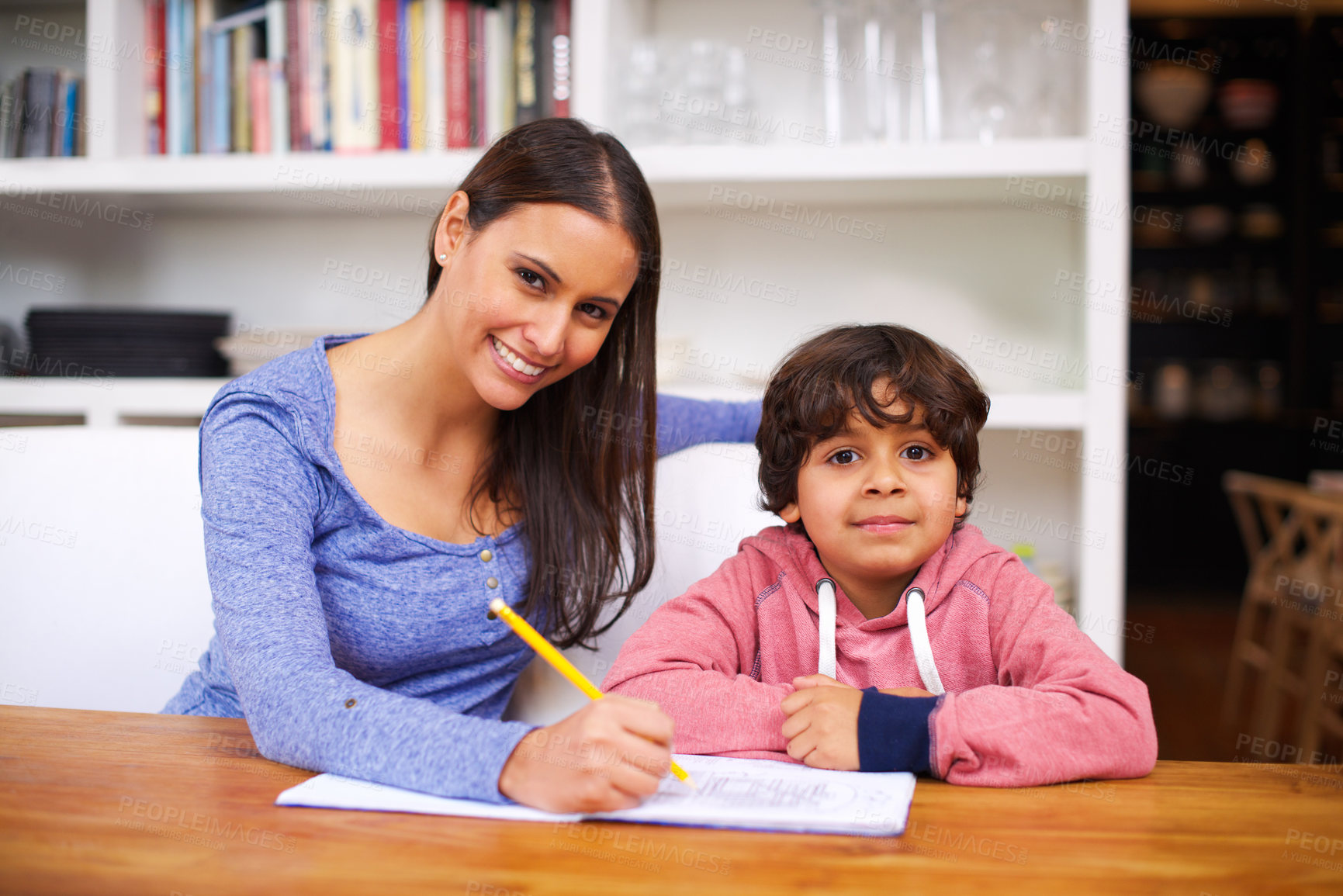 Buy stock photo Mother, child and portrait with book for homework, help and education for learning, study and development. Indian people, woman and boy with smile and pencil for teach, writing and grades in house