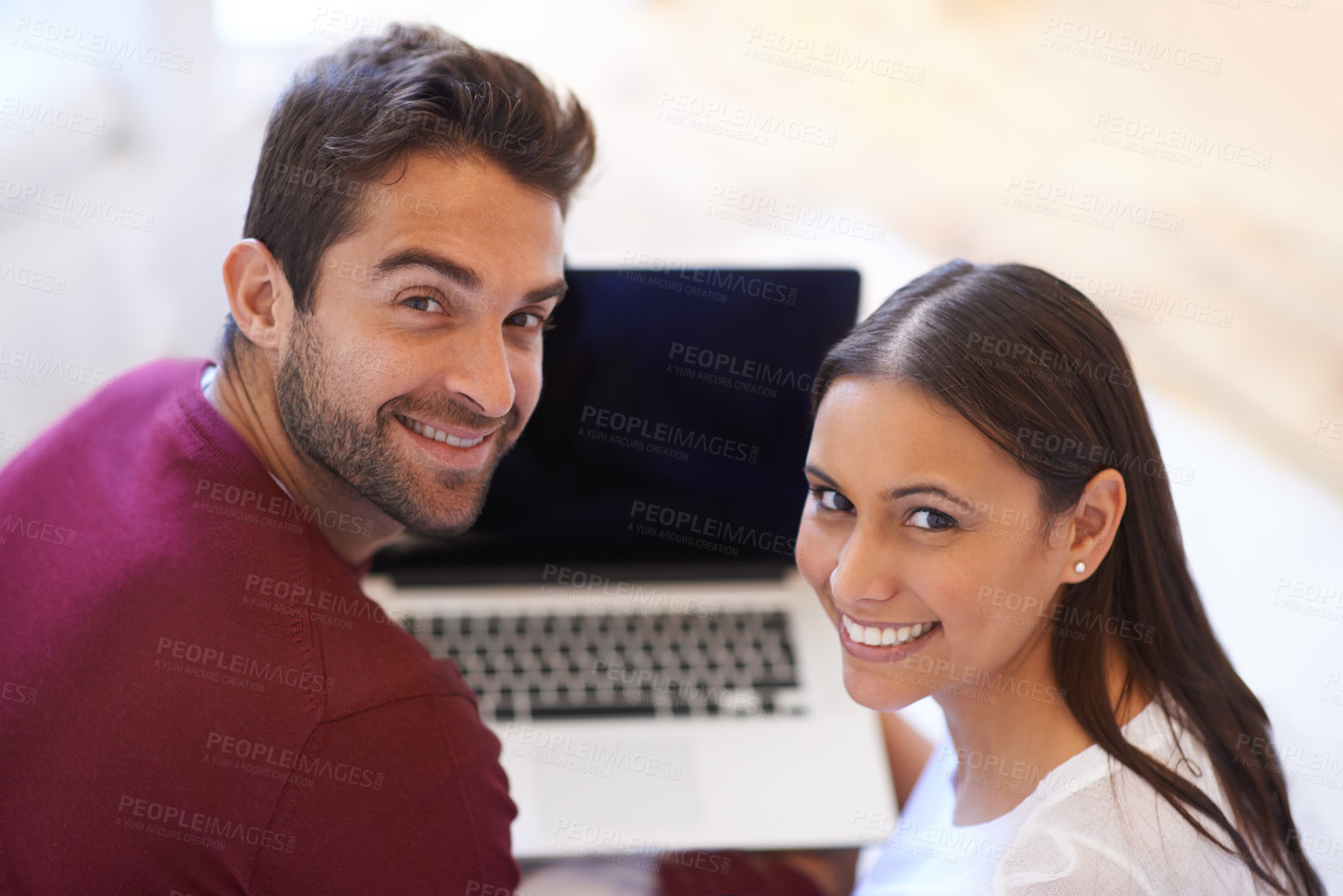 Buy stock photo A happy young couple using their laptop together at home