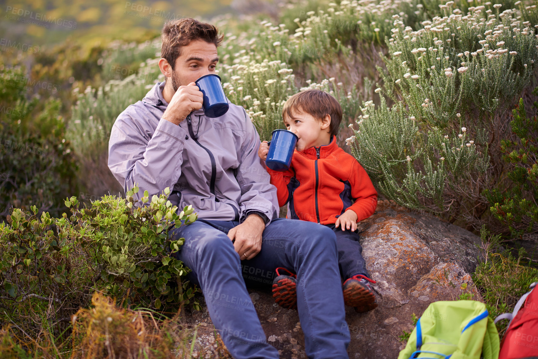 Buy stock photo Father, child and drinking with hiking, backpack and camping with smile and support in nature. Kid, adventure and mountain with love, trust and bonding together with family and travel for holiday