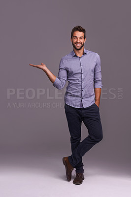 Buy stock photo Happy man, portrait and presentation with palm for advertising, marketing or showcase on a gray studio background. Young and handsome male person or employee with smile showing option on mockup space