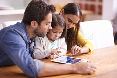 Buy stock photo Mom, dad and child at table with tablet for teaching, learning and support in education with love. Elearning, digital app and parents with girl for help in homeschool, growth and development online