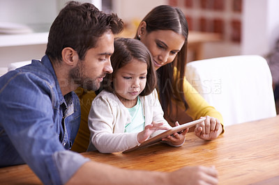 Buy stock photo Mother, father and child at table with tablet for teaching, learning or support in education. Elearning, digital app and parents with girl for help in homeschool, growth or development in online game