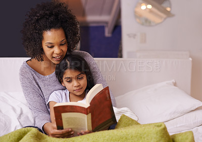 Buy stock photo Cropped shot of a young mother reading to her daughter at home