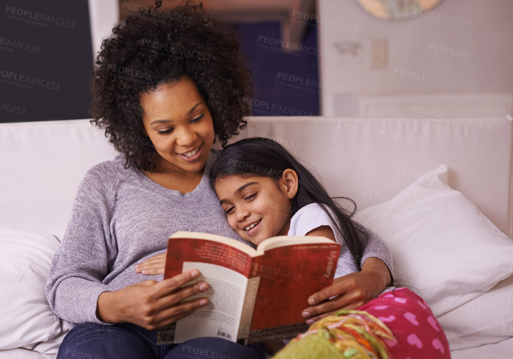 Buy stock photo Cropped shot of a young mother reading to her daughter at home