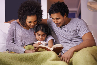 Buy stock photo Family, child and reading a book together in a home for story time on a lounge sofa with a smile. A woman, man or parents and girl kid for development, learning and love with a fantasy or fairytale